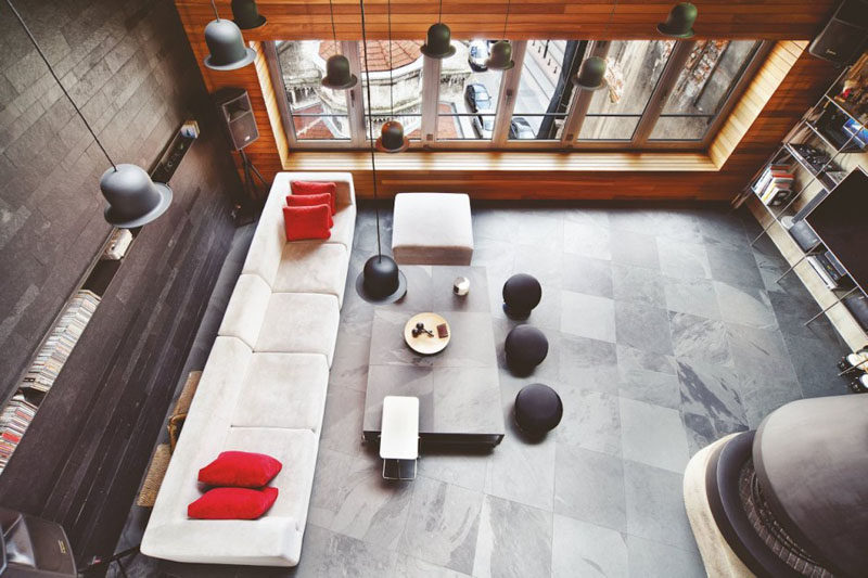 Interior Design Ideas - 17 Modern Living Rooms As Seen From Above | The stone tiles along the back wall of this living room combined with the wood feature wall and stone tiles give this loft an industrial yet warm feel.