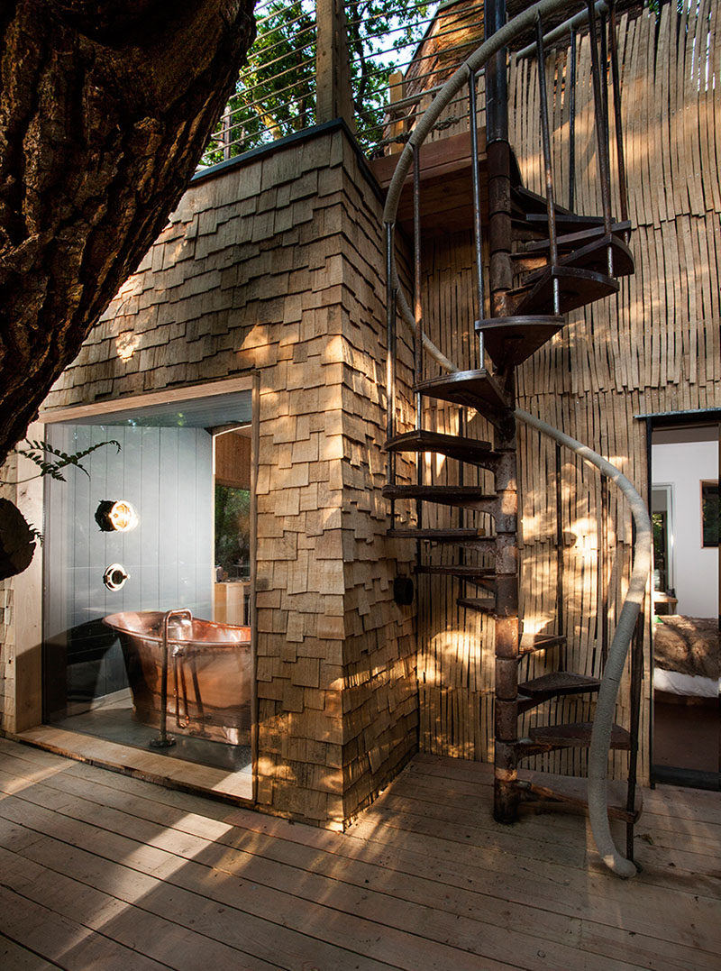 A spiral staircase leads you up to the second storey of this treehouse for adults.