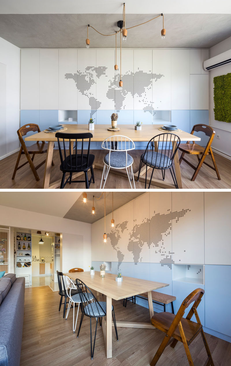Behind this dining table, a wall of cabinets has a couple of small cut-outs that are used as shelves, and a map of the world has been added as an artistic feature.
