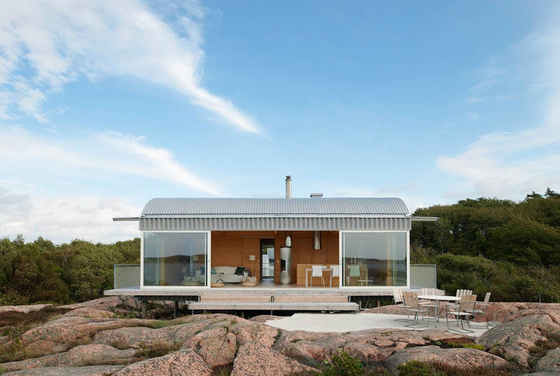19 Examples Of Modern Scandinavian House Designs | Large glass windows make up the front of this summer house to take advantage of the seaside views.